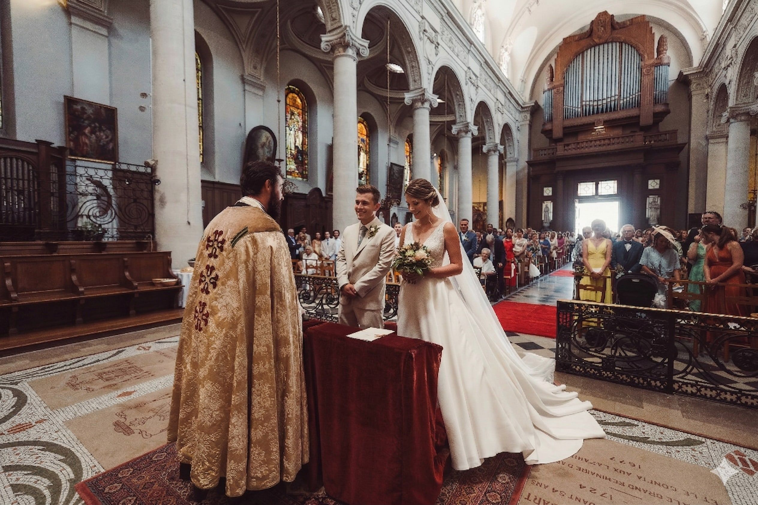 Les mariés devant l’autel pendant la cérémonie religieuse, l’assemblée derrière eux.